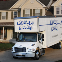 mg moving large truck parked in the driveway of a new hoe