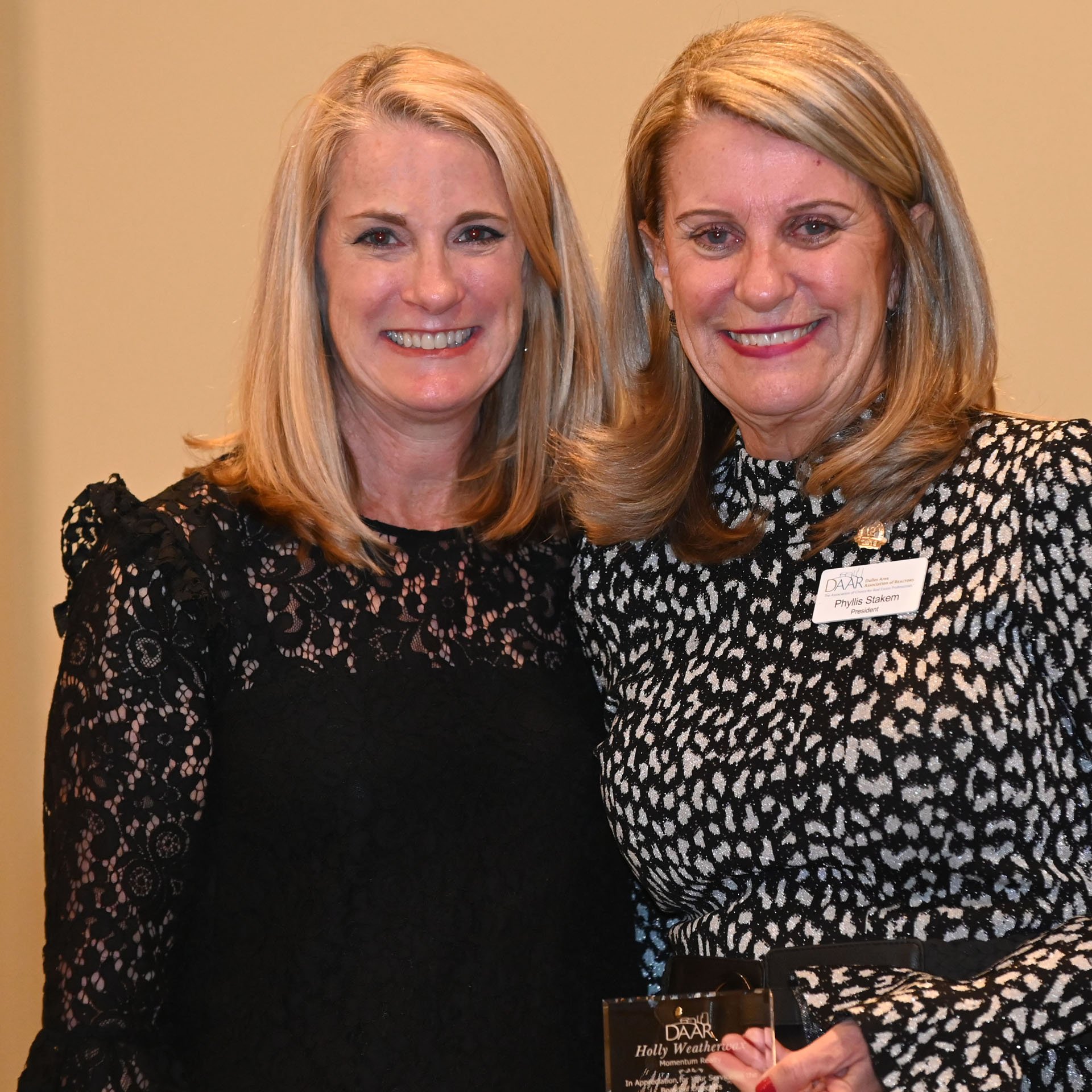 Dulles Area Association of Realtors President Phyllis Stakem handing a plaque to member Holly Weather