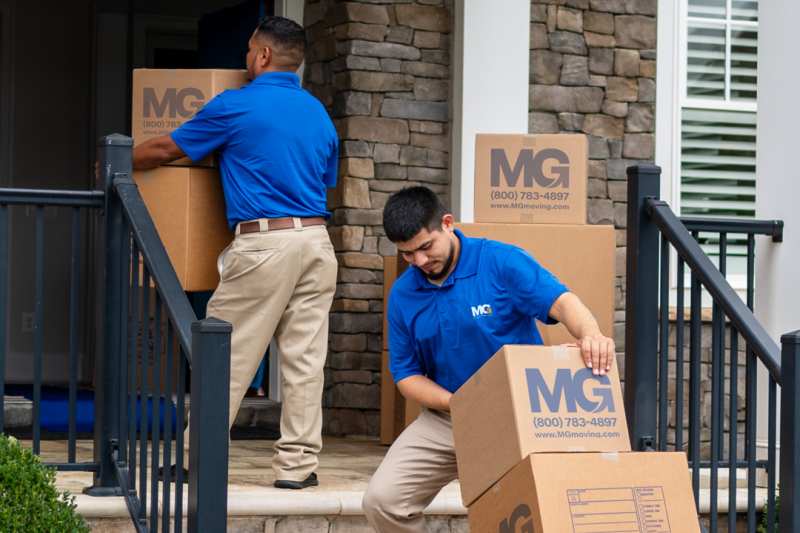 two-movers-carrying-boxes-handtruck-stairs