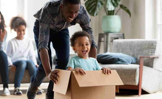 dad and son playing with moving boxes during a moving day