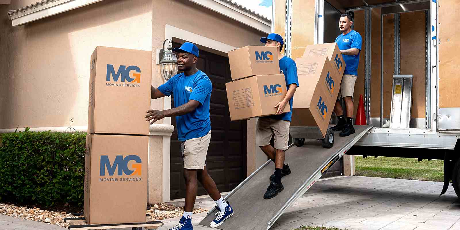 moving professional carrying boxes down the moving truck