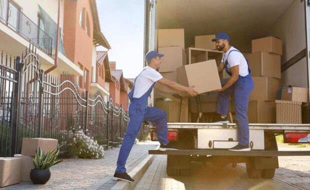 workers unloading boxes from van outdoors