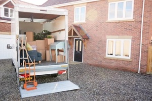 removal truck waiting to be unloaded outside new home on moving day