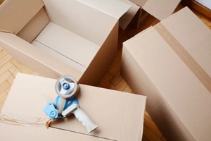 tape dispenser sealing a shipping cardboard box
