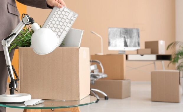 businesswoman packing box in office on moving day